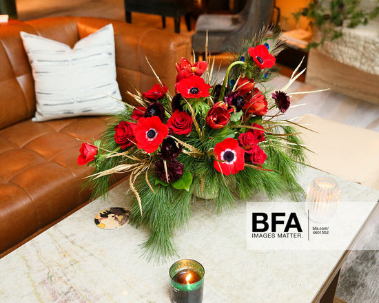 table flower arrangement with pine and red flowers